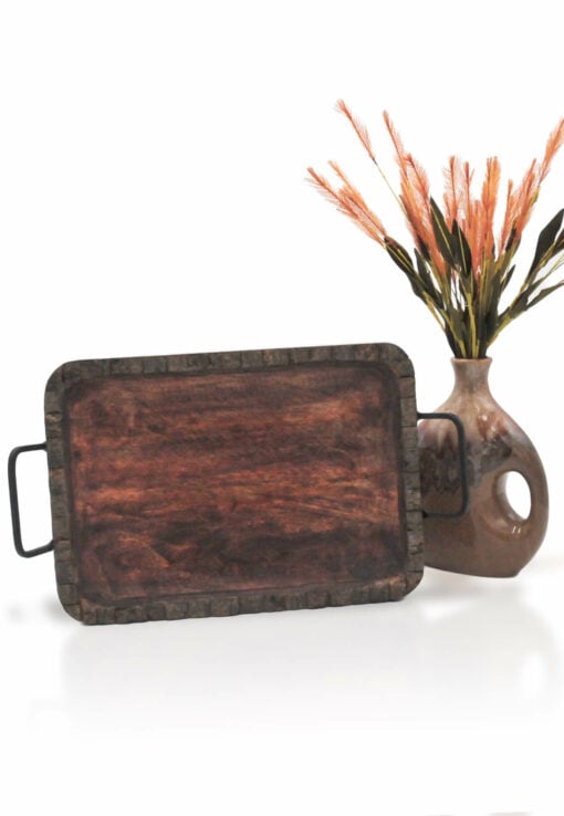 The Woodland Rolling Tray, featuring black metal handles, stands upright next to a brown ceramic vase with orange and green artificial flowers on a white background.