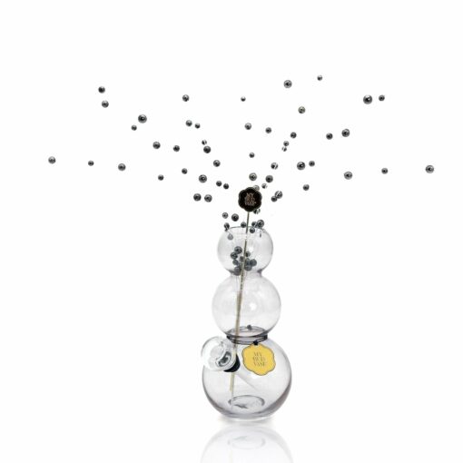 The Bubbles Vase Bong is a clear glass piece featuring three round sections and a thin stick with small metallic spheres suspended like bubbles, creating a spray pattern against a white background.