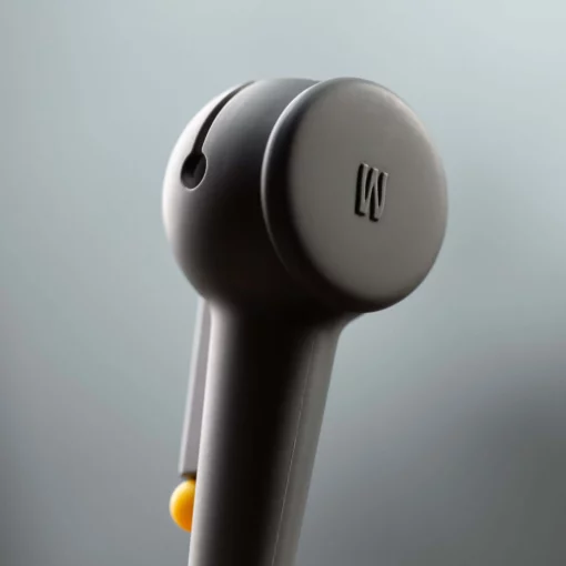 A close-up of The Pipe - Smoke wireless earbud, featuring a raised W logo on its side, set against a softly blurred gray background evocative of swirling smoke.