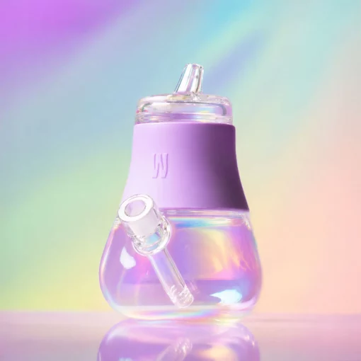 The Iridescent Bubbler - Lavender features a glass body with a curved base, angled mouthpiece, and lavender silicone grip, set against a soft pastel rainbow background.