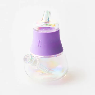 The Iridescent Bubbler - Lavender is a small, curved glass water pipe with an iridescent finish, a lavender silicone band around the middle, a mouthpiece, and a removable bowl.