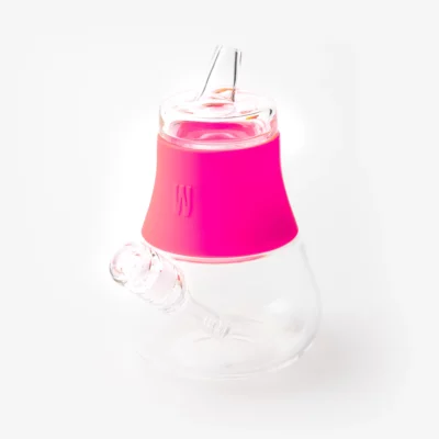 The Bubbler - Hot Pink is a clear glass water pipe with a wide base, hot pink silicone bubbler midsection, and protruding mouthpiece and bowl adapter, shown against a plain white background.