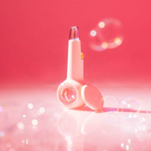 The Pipe Iridescent - Bubblegum stands upright on a glossy surface, surrounded by bubblegum-pink bubbles and set against a dreamy pink background with playful, iridescent shimmer.