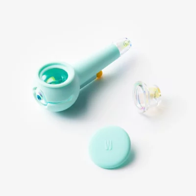 The Pipe Iridescent - Sky: a sky-blue iridescent smoking pipe with a transparent bowl, matching round lid, and separate clear glass bowl attachment, shown on a white background.