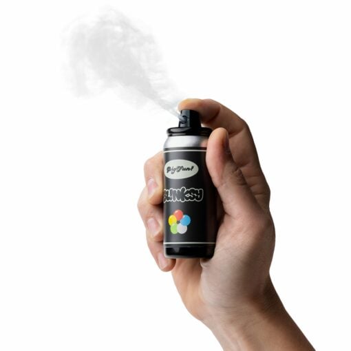A hand sprays a black BIGFUN! Blinksy Vaporizer can with colorful circles and text on the label, set against a white background.