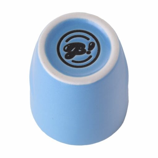 A small, light blue ceramic cup is turned upside down to reveal a white base with a black stylized B! logo—perfect for adding to your BigFUN! Potheads Ashtray Set.