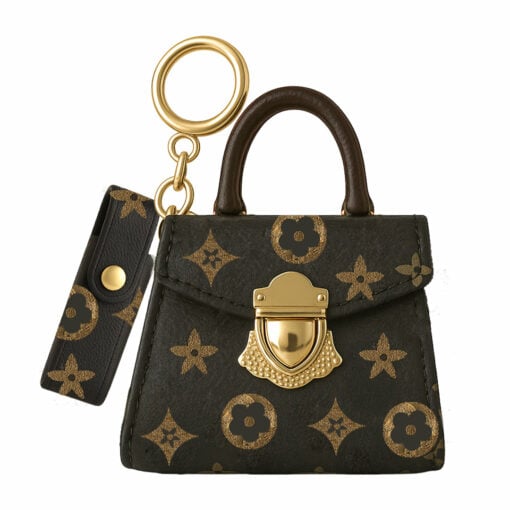 A small black and gold Penjamin Pursejamin Vaporizer with a patterned design, gold clasp, matching key fob, and both attached to a gold keyring.