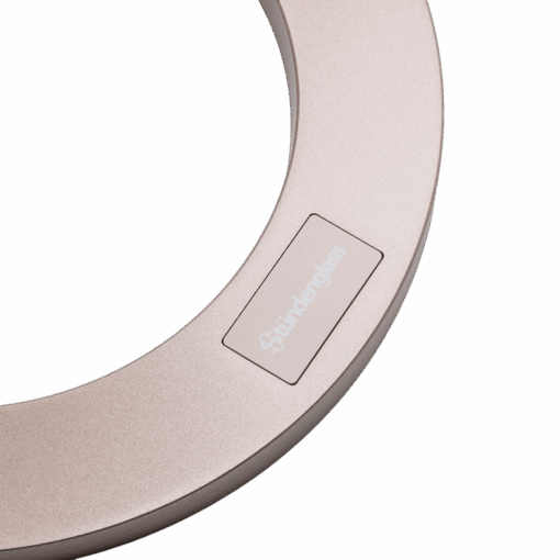 Close-up of a circular, metallic object with a smooth matte finish and a label reading fünfunder glass, resembling the refined design of the Stündenglass Gravity Infuser - Desert Rose | 360° Gravity Hookah against a white background.