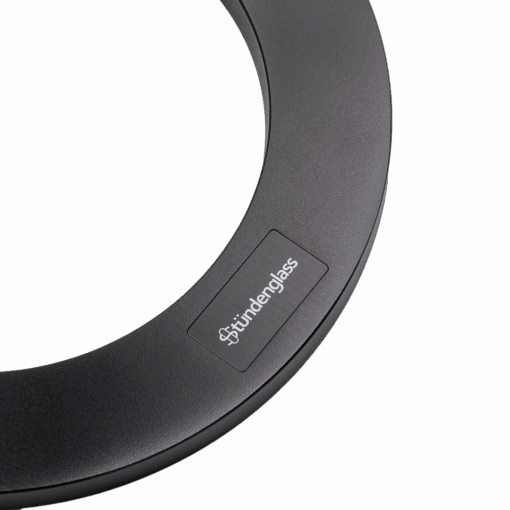 A close-up of a black circular part from the Stündenglass Gravity Infuser | 360° Gravity Hookah & Infusion System, with a small rectangular label that reads "stündenglass" in white text against a white background.