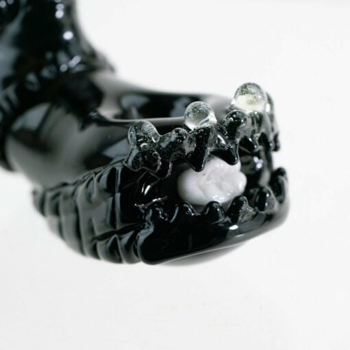 Empire Glassworks Alien Hand Pipe featuring a sculpted alien design with black glass body, white teeth details, and glow-in-the-dark beads.