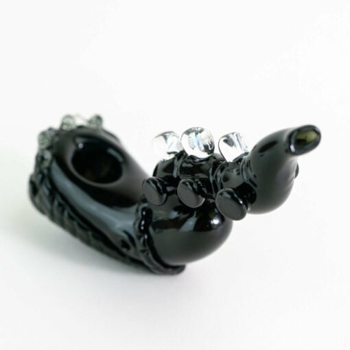 Empire Glassworks Alien Hand Pipe featuring a sculpted alien design with black glass body, white teeth details, and glow-in-the-dark beads.